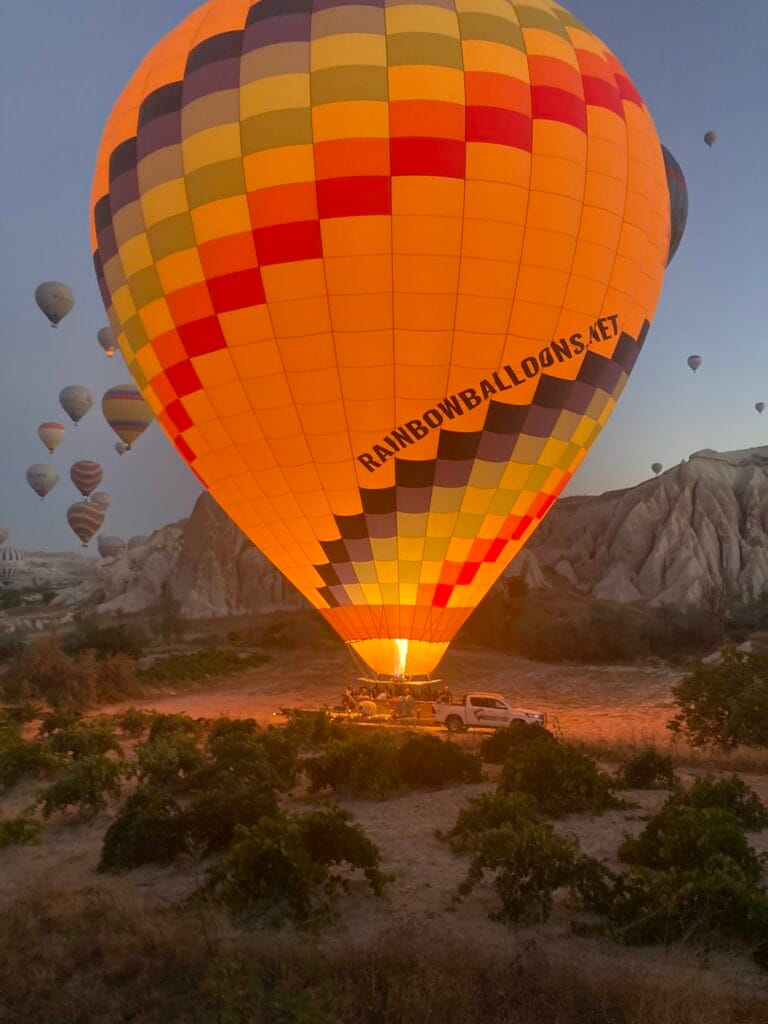 Bij dageraad door gasbrander verlichte luchtballon Cappadocia