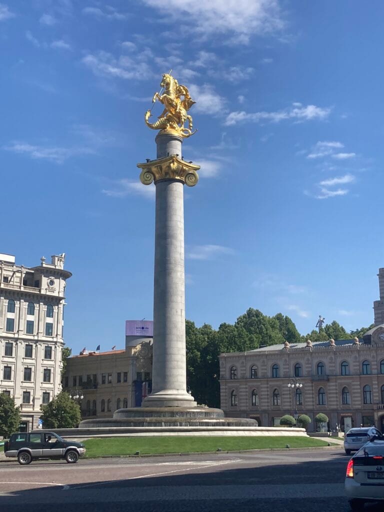 Freedom Monument in Tbilisi: hoge zuil met gouden beeld van St. George die een draak verslaat